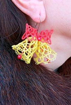 a close up of a person wearing large earrings with lace on the back of their ear