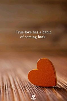 an orange heart sitting on top of a wooden table next to a quote that says true love has a habitt of coming back