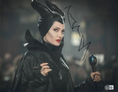 a woman dressed as maleficent holding a cross