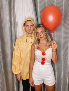 a man and woman dressed in costumes posing for a photo with red balloons attached to them