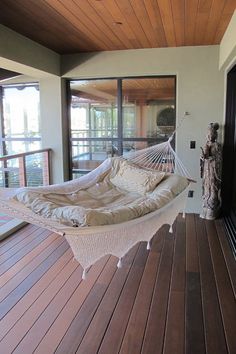 a hammock hanging from the side of a wooden floor next to a door