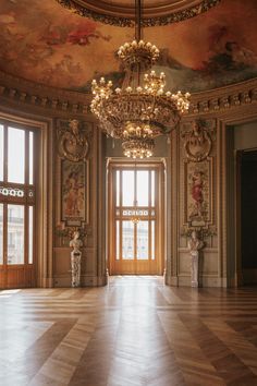 an ornate room with chandelier and paintings on the walls