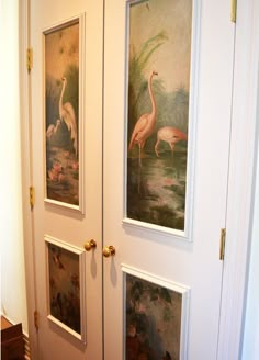 two doors with paintings on them in the hallway