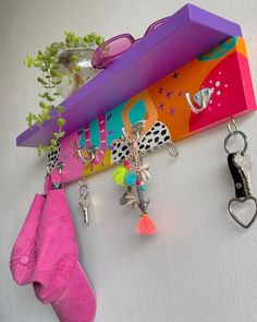 a pair of pink socks hanging from a hook on a wall with keychains