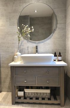 a bathroom sink with a mirror above it and a vase on the counter next to it