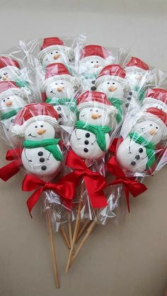 a bunch of snowmen sitting on top of each other in plastic wrappers with red bows