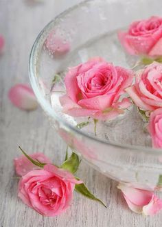 two pink roses in a glass bowl with water on the side and an arabic quote above it