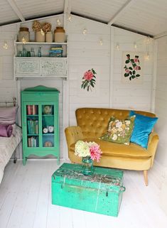 a living room filled with furniture and flowers on top of a coffee table in front of a bed