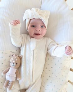 a baby is laying down next to a teddy bear