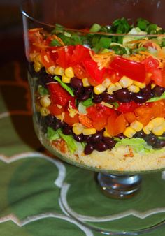 a layered salad in a glass dish on a table