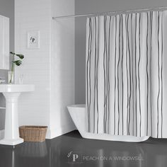 a white bathroom with black and white striped shower curtain, pedestal sink and bathtub