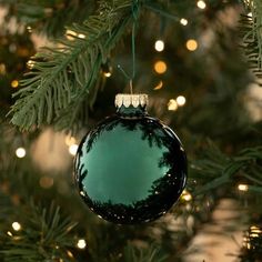 a green ornament hanging from a christmas tree