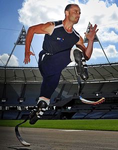 a man is jumping in the air with his legs spread out to catch a frisbee