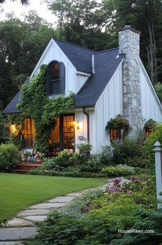 a white house surrounded by greenery and flowers