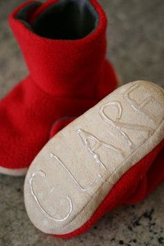 a pair of red slippers with the word love written on them sitting on a granite floor