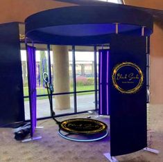 an exhibit booth with blue walls and purple carpeted flooring in front of large windows