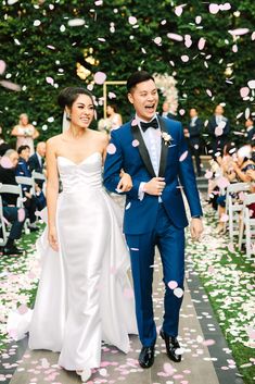 a bride and groom walk down the aisle as confetti is thrown around them