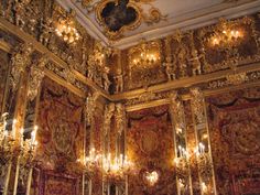 an ornately decorated room with chandeliers and gold paint on the walls,