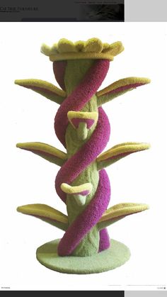 a purple and green cat toy with three tails on it's head, sitting in front of a white background