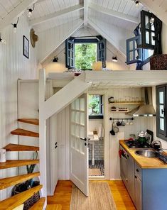 a kitchen with stairs leading up to the loft