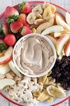 a plate filled with fruit, nuts and dip