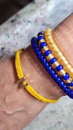 These uniquely creative items are carefully handcrafted by me, a MidMom, and are available in limited in quantity. These handcrafted bracelets are a beautiful way to show off your Navy spirit, are promotionally priced, and may not be available for awhile or ever again - when they are gone, they may be gone forever! Available Now: Woven Yellow or Blue Bracelets with Gold N Charm Woven Yellow & Blue combined with Gold N Charm Woven Bracelets with White N Bead Pave Crystal charms Bracelets (Aviatio Yellow Braided Bracelet For Gift, Yellow Letter Beads Friendship Bracelets As Gift, Yellow Letter Beads Friendship Bracelet Gift, Gift Yellow Letter Beads Friendship Bracelets, Customizable Adjustable Yellow Jewelry, Adjustable Customizable Yellow Jewelry, Personalized Yellow Beaded Bracelets As Gift, Personalized Yellow Beaded Bracelets For Gifts, Personalized Yellow Beaded Bracelet As Gift