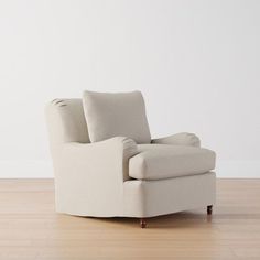 a white chair sitting on top of a hard wood floor next to a white wall