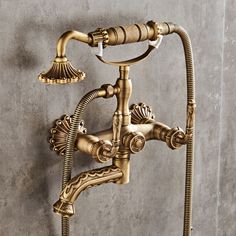 an antique brass faucet with two hoses attached to the side of it