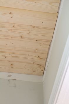 the corner of a room with wood paneling on the ceiling