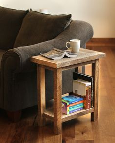 a coffee table with books and a cup on it sitting in front of a couch