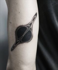 a man's arm with a black and white tattoo design on the left side of his arm