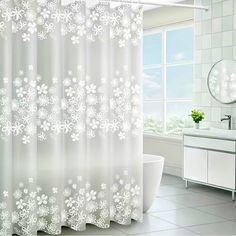 a bathroom with a toilet, sink and shower curtain in the window is decorated with snowflakes