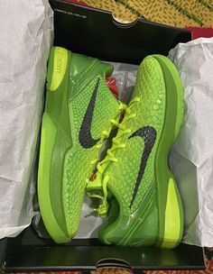 a pair of green nike shoes in a box