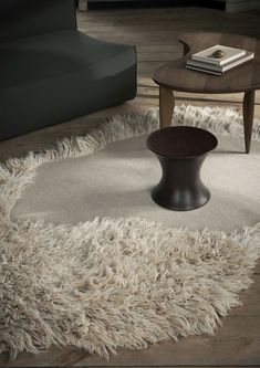 a living room with a round rug on the floor next to a chair and coffee table