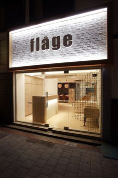 a store front with the word fage lit up at night