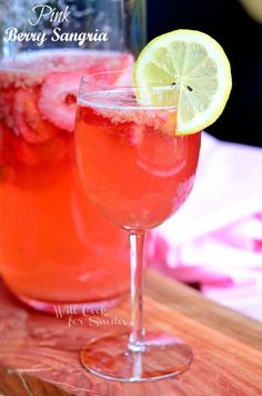 two glasses filled with watermelon and lemonade sitting on a wooden cutting board