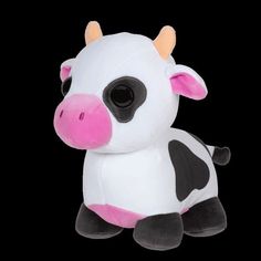 a small stuffed cow sitting on top of a black background