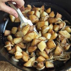 someone is frying some potatoes in a skillet