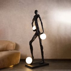 a statue is standing in front of a couch with two lights on it's legs