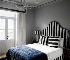 a black and white bedroom with striped bedding