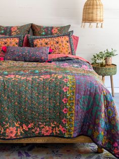 a bed with colorful bedspread and pillows on it