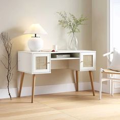 a white desk with two drawers and a lamp next to it on top of a hard wood floor