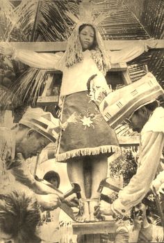 an old black and white photo of a woman standing on top of a statue with other people around her