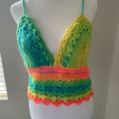 a white mannequin wearing a multicolored crocheted halter top