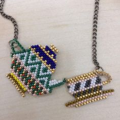 two pieces of bead art hanging from chains