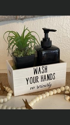 a soap dispenser sitting on top of a table next to a plant