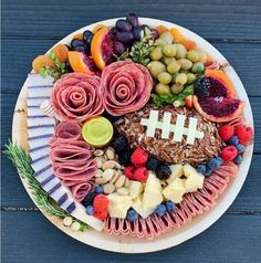 a football themed platter with fruit, vegetables and meats on it for a super bowl party