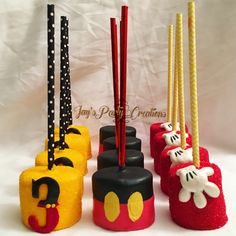 four decorated candles in the shape of mickey mouses