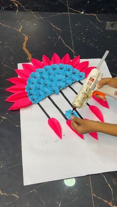 a person using glue to decorate a flower