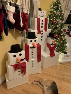 a dog is looking at snowmen made out of boxes